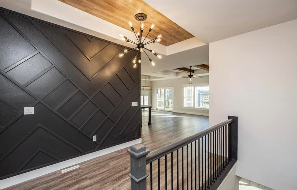 Mid-sized minimalist vinyl floor, brown floor and tray ceiling foyer photo in Cedar Rapids with black walls