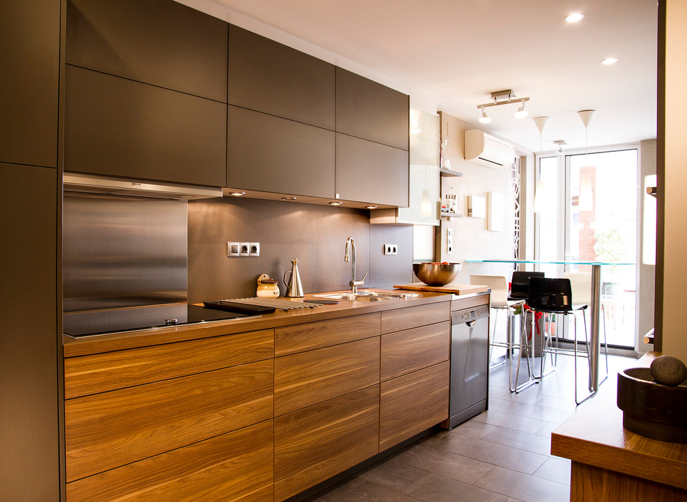 Mid-sized modern galley eat-in kitchen in Barcelona with a farmhouse sink, flat-panel cabinets, dark wood cabinets, laminate benchtops, grey splashback, timber splashback, stainless steel appliances, porcelain floors, no island and grey floor.