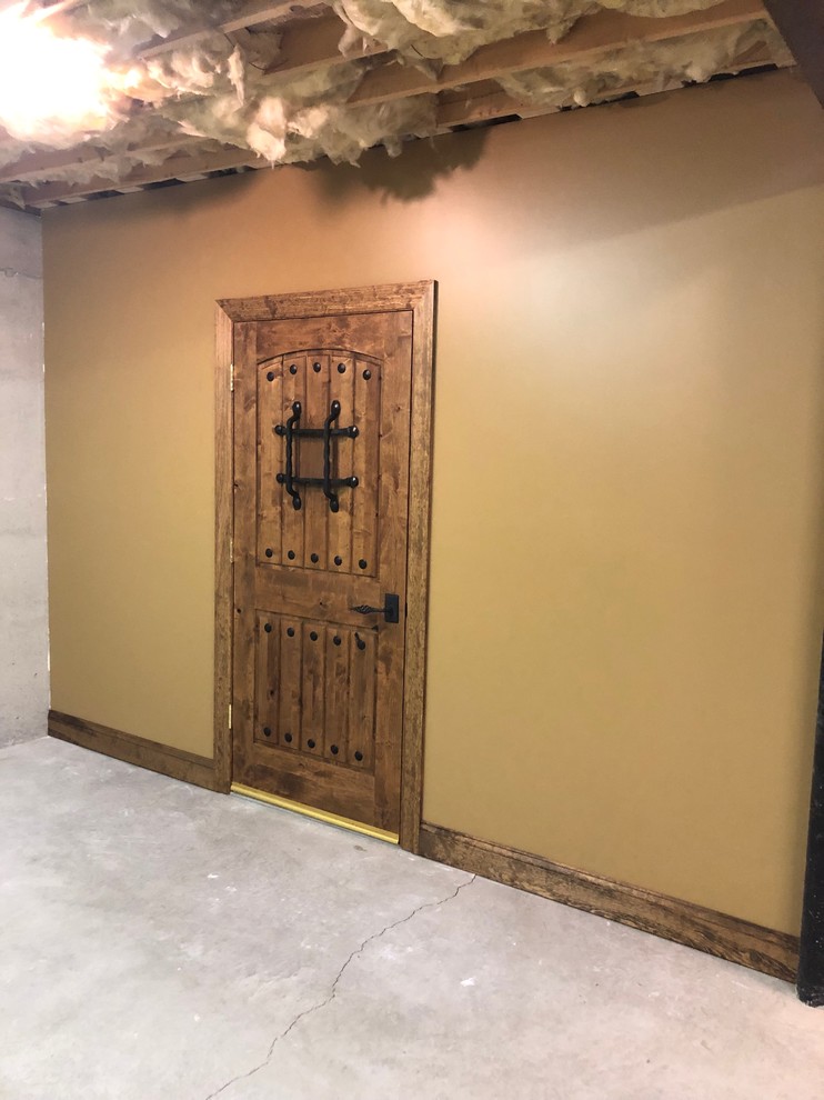 Inspiration for a mid-sized rustic laminate floor and brown floor wine cellar remodel with display racks
