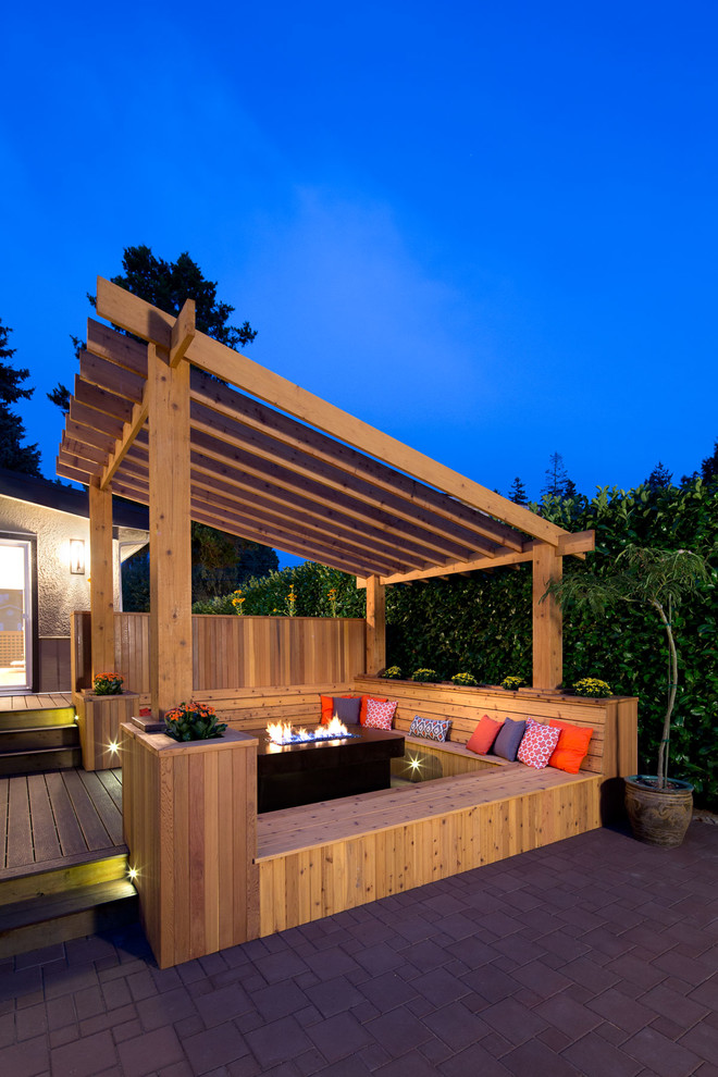 Photo of a transitional deck in Vancouver with a pergola.