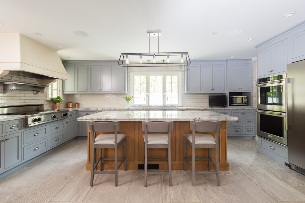 Enclosed kitchen - large transitional u-shaped porcelain tile and gray floor enclosed kitchen idea in Los Angeles with a drop-in sink, shaker cabinets, quartzite countertops, white backsplash, ceramic backsplash, stainless steel appliances, an island and gray countertops