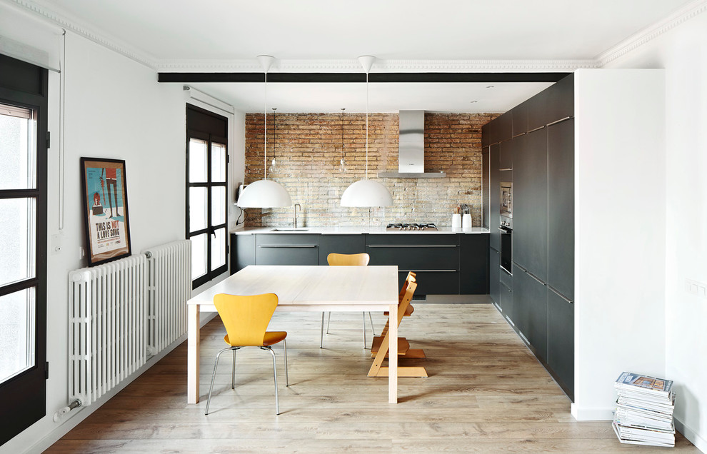 Design ideas for a mid-sized eclectic l-shaped separate kitchen in Barcelona with an undermount sink, flat-panel cabinets, black cabinets, light hardwood floors, no island, stainless steel appliances and brown splashback.