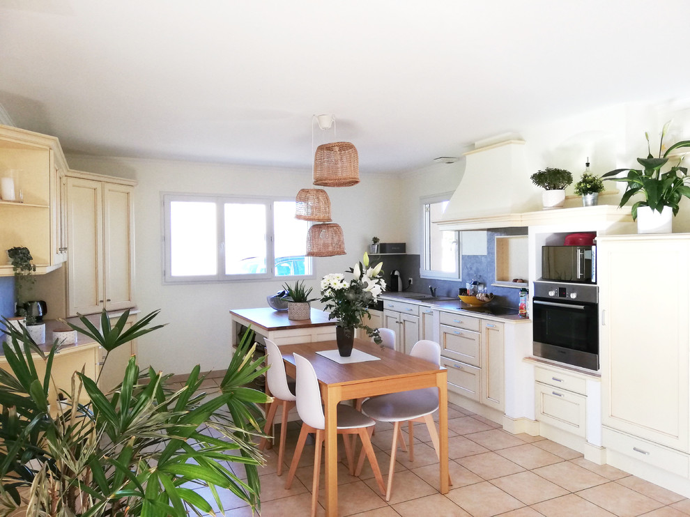 Photo of a large beach style galley open plan kitchen in Nantes with an undermount sink, recessed-panel cabinets, beige cabinets, granite benchtops, grey splashback, ceramic floors, with island, pink floor and pink benchtop.