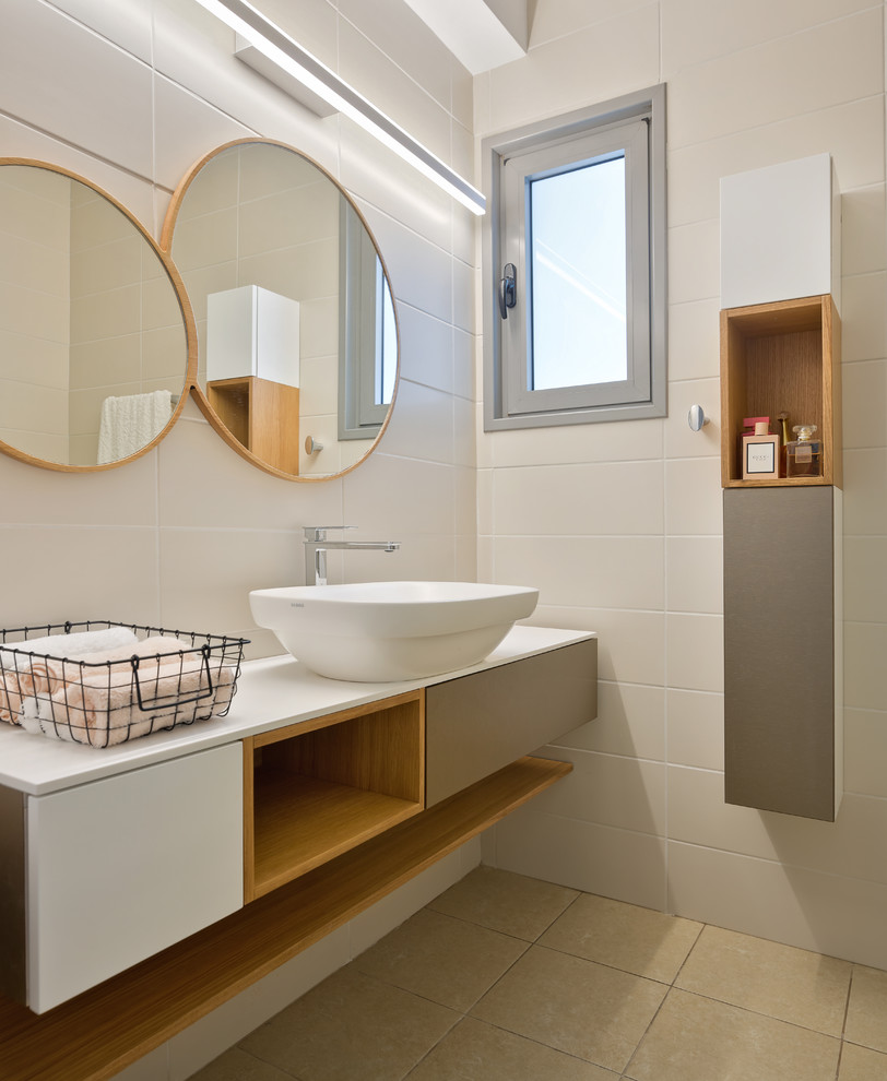 Photo of a contemporary powder room in Milan with white benchtops, flat-panel cabinets, grey cabinets, beige tile, a vessel sink and beige floor.