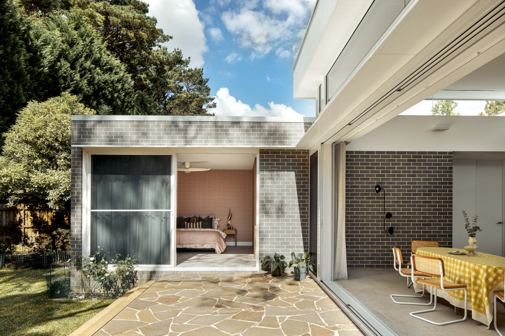 This is an example of a mid-sized midcentury backyard deck in Sydney with no cover.