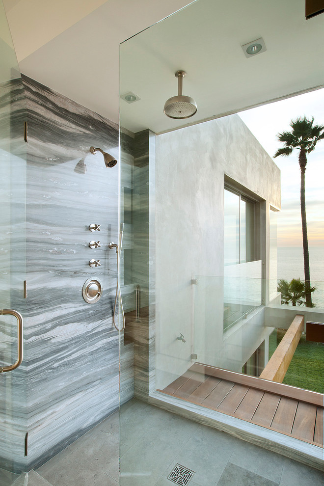 Beach style bathroom in Los Angeles with gray tile, stone slab and a hinged shower door.