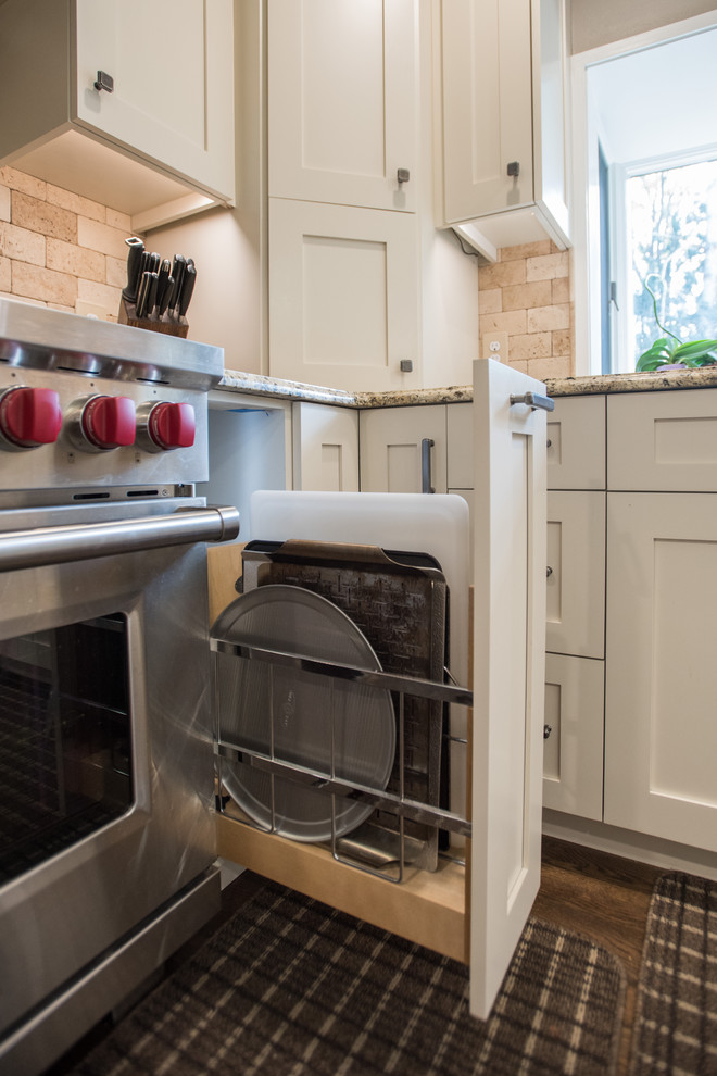 Eat-in kitchen - large transitional u-shaped medium tone wood floor and brown floor eat-in kitchen idea with an undermount sink, shaker cabinets, white cabinets, granite countertops, beige backsplash, travertine backsplash, paneled appliances and an island