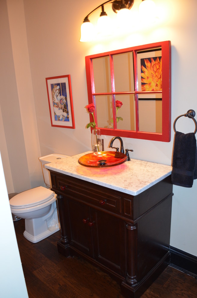 Photo of a mid-sized modern powder room in Other with recessed-panel cabinets, dark wood cabinets, a two-piece toilet, white walls, dark hardwood floors, a vessel sink and granite benchtops.