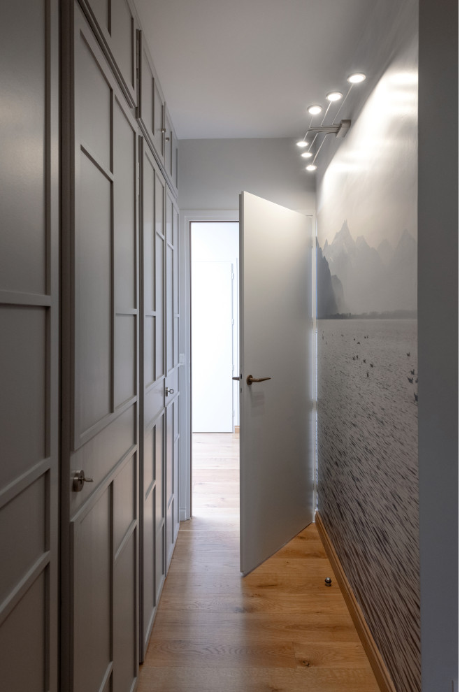 Modern inredning av en liten hall, med grå väggar, ljust trägolv och beiget golv
