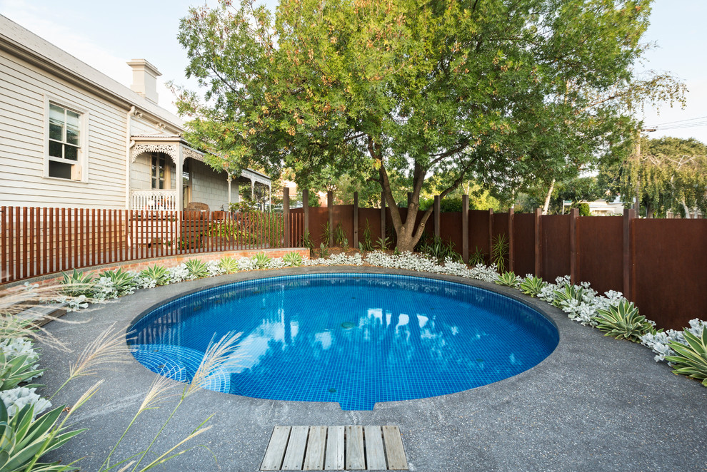 Mid-sized modern side yard round pool in Melbourne with gravel.