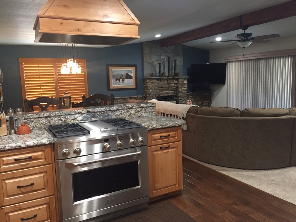 Inspiration for a mid-sized rustic u-shaped medium tone wood floor kitchen remodel with an undermount sink, raised-panel cabinets, light wood cabinets, granite countertops, white backsplash, ceramic backsplash and stainless steel appliances