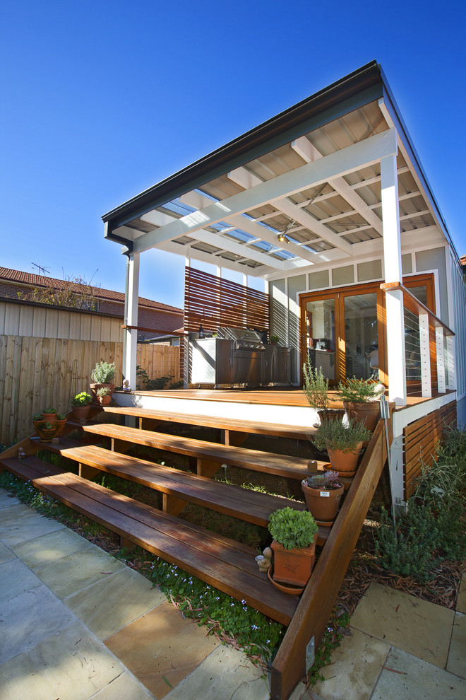 This is an example of a mid-sized contemporary balcony in Sydney with a container garden and a roof extension.