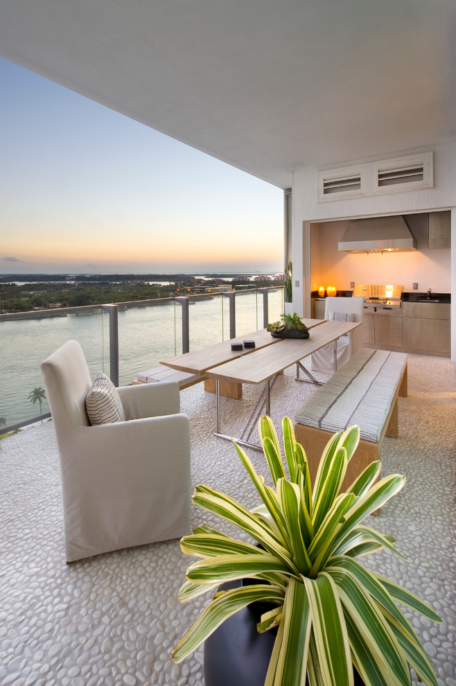 This is an example of a contemporary deck in Miami with an outdoor kitchen.