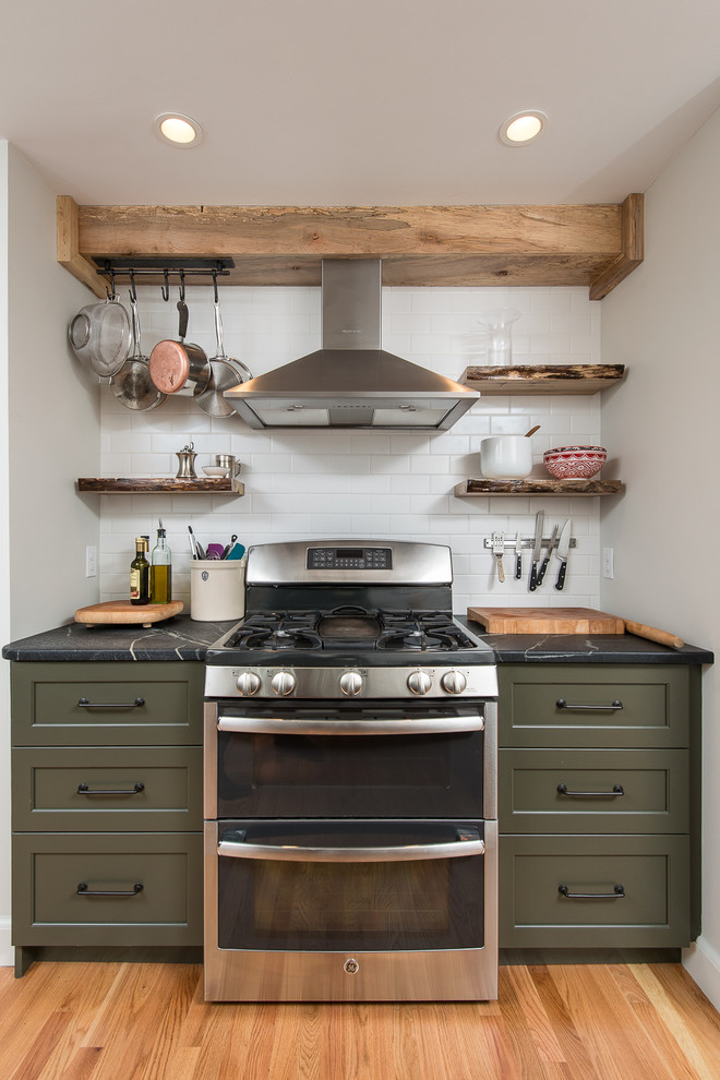 Example of a mid-sized transitional l-shaped eat-in kitchen design in Boston with recessed-panel cabinets, green cabinets, soapstone countertops, white backsplash, subway tile backsplash, stainless steel appliances and a peninsula