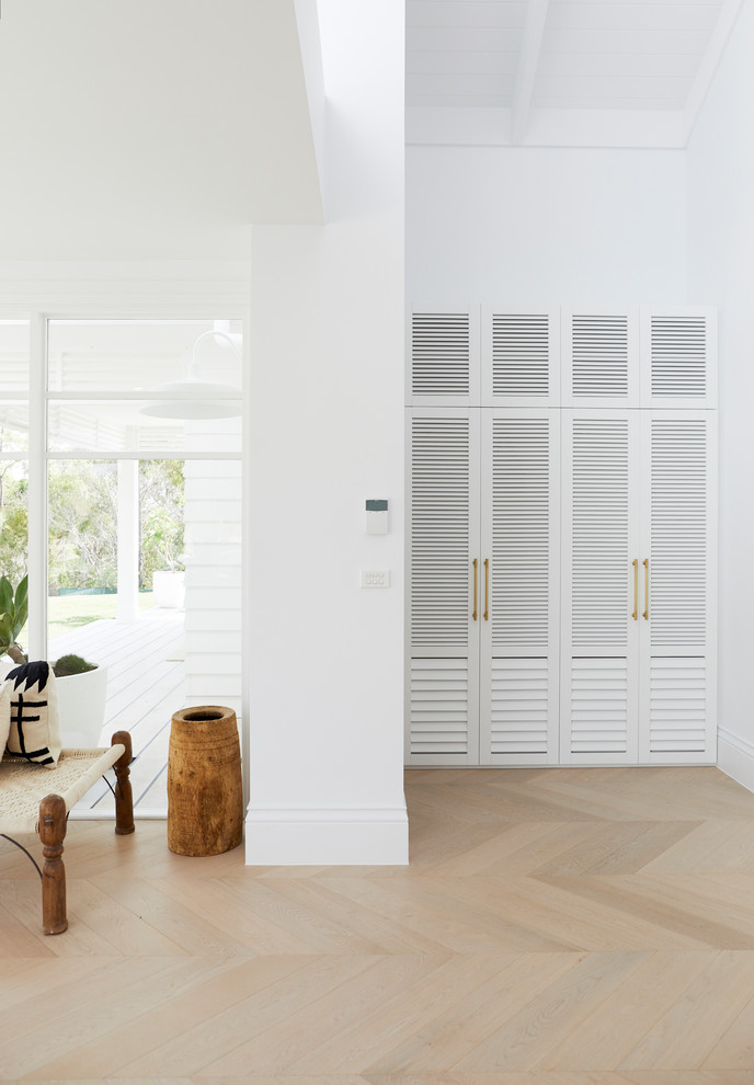 Mid-sized beach style mudroom in Sydney with white walls.