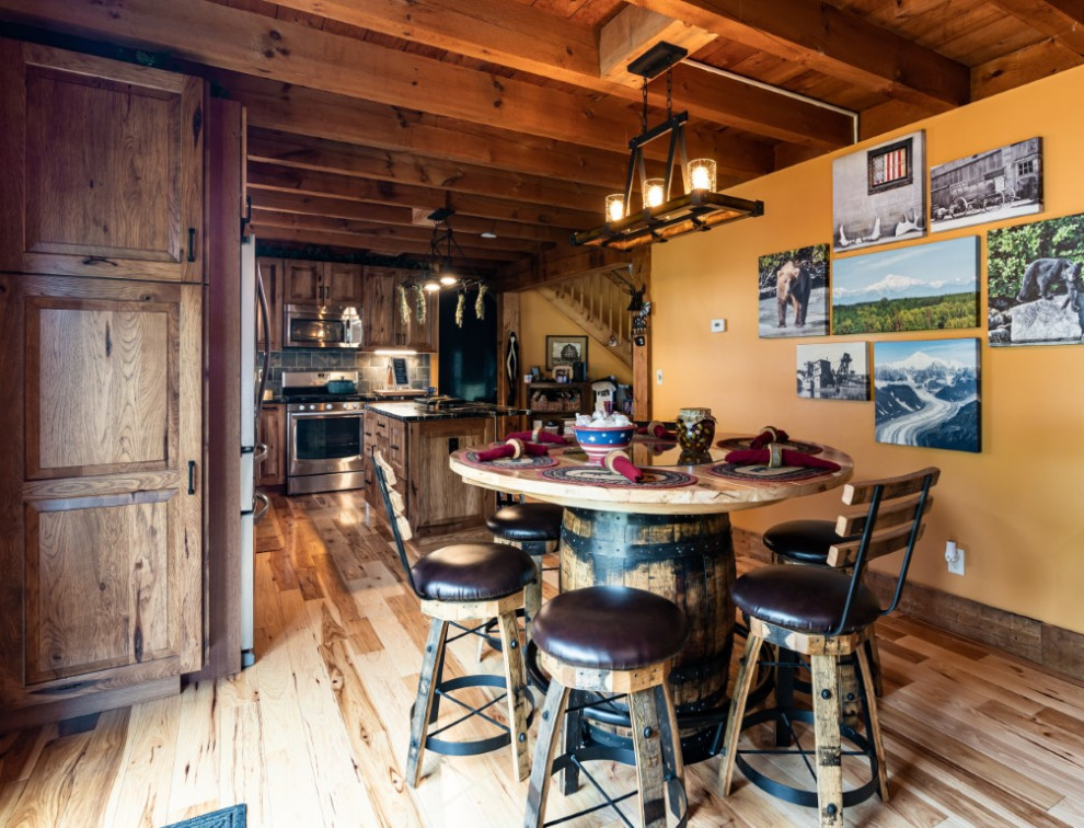 Mountain style l-shaped medium tone wood floor kitchen photo in Boston with an undermount sink, raised-panel cabinets, medium tone wood cabinets, granite countertops, gray backsplash, stainless steel appliances, an island and black countertops