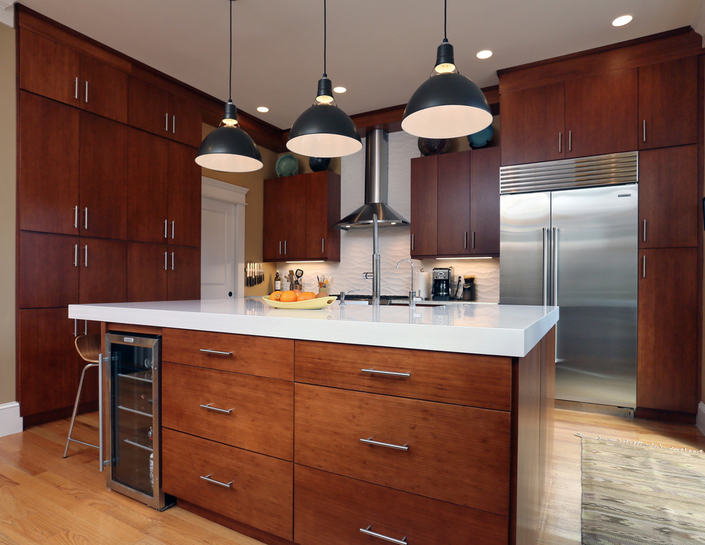 Design ideas for a mid-sized modern l-shaped eat-in kitchen in Boston with a farmhouse sink, flat-panel cabinets, medium wood cabinets, quartz benchtops, white splashback, stainless steel appliances, medium hardwood floors and with island.
