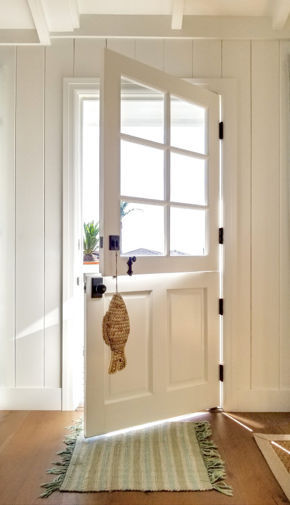 This is an example of a beach style entryway in San Francisco with white walls, medium hardwood floors, a dutch front door, a white front door, brown floor, exposed beam, timber, vaulted and planked wall panelling.
