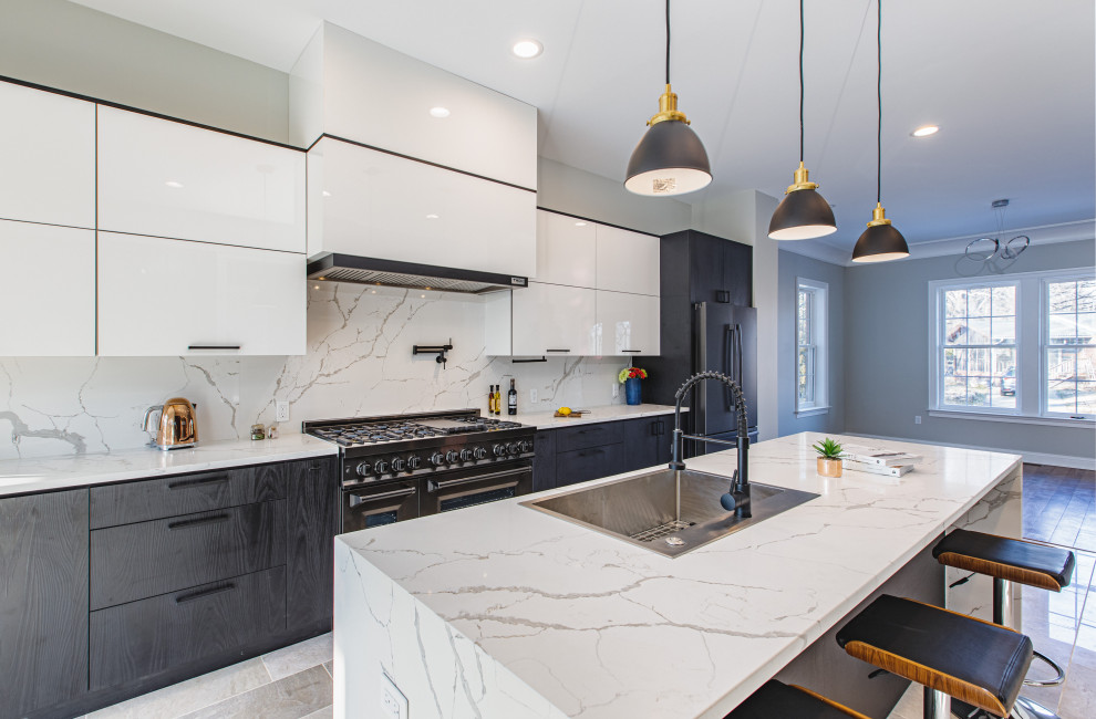 This is an example of a large modern galley open plan kitchen in DC Metro with a drop-in sink, flat-panel cabinets, white cabinets, quartz benchtops, white splashback, engineered quartz splashback, black appliances, marble floors, with island, beige floor and white benchtop.