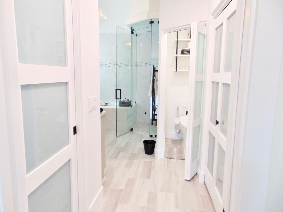 Cette image montre une grande salle de bain principale et grise et blanche marine avec un placard à porte shaker, des portes de placard grises, une baignoire posée, une douche à l'italienne, un bidet, un carrelage blanc, des carreaux de porcelaine, un mur blanc, un sol en carrelage de porcelaine, un lavabo encastré, un plan de toilette en quartz modifié, un sol gris, une cabine de douche à porte battante, un plan de toilette gris, meuble double vasque, meuble-lavabo encastré et un plafond à caissons.