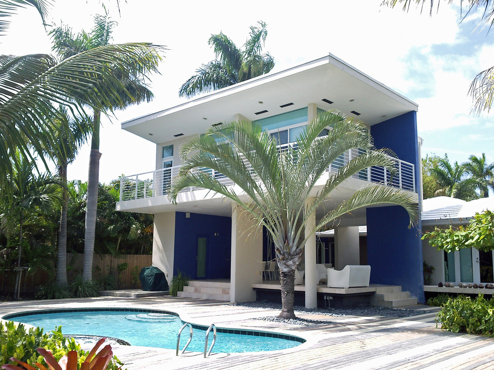 Photo of a large contemporary two-storey stucco white house exterior in Miami with a flat roof.