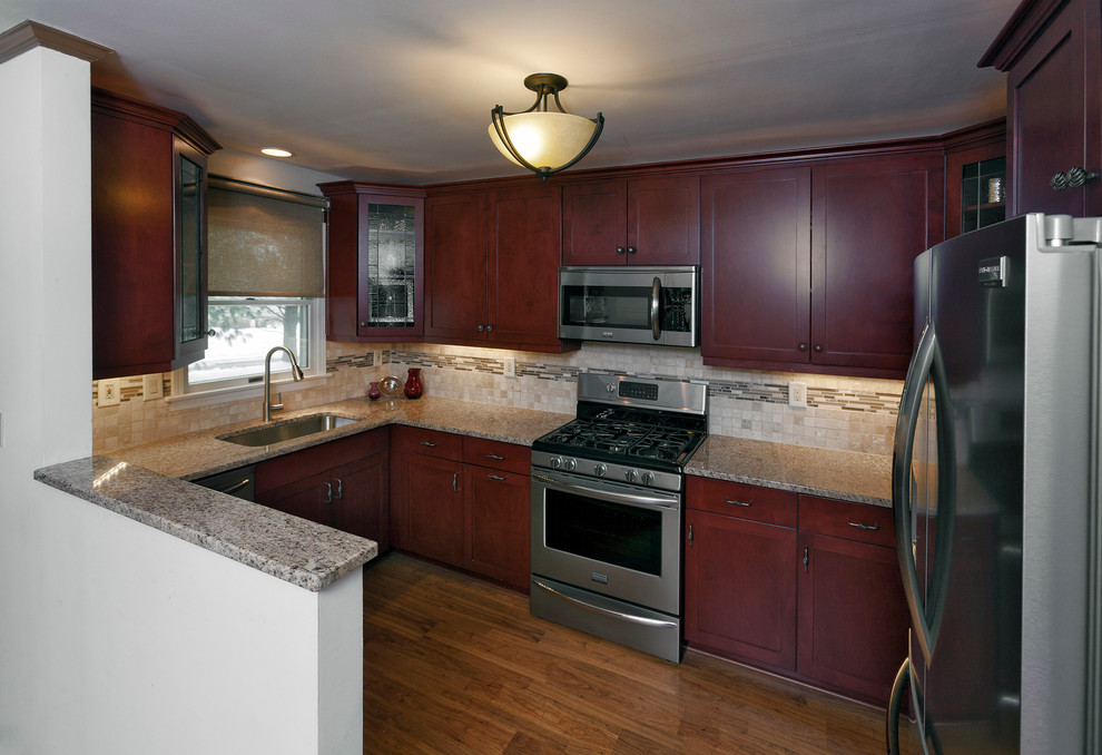 Inspiration for a mid-sized transitional u-shaped light wood floor eat-in kitchen remodel in Miami with an undermount sink, shaker cabinets, medium tone wood cabinets, granite countertops, beige backsplash, matchstick tile backsplash, stainless steel appliances and no island