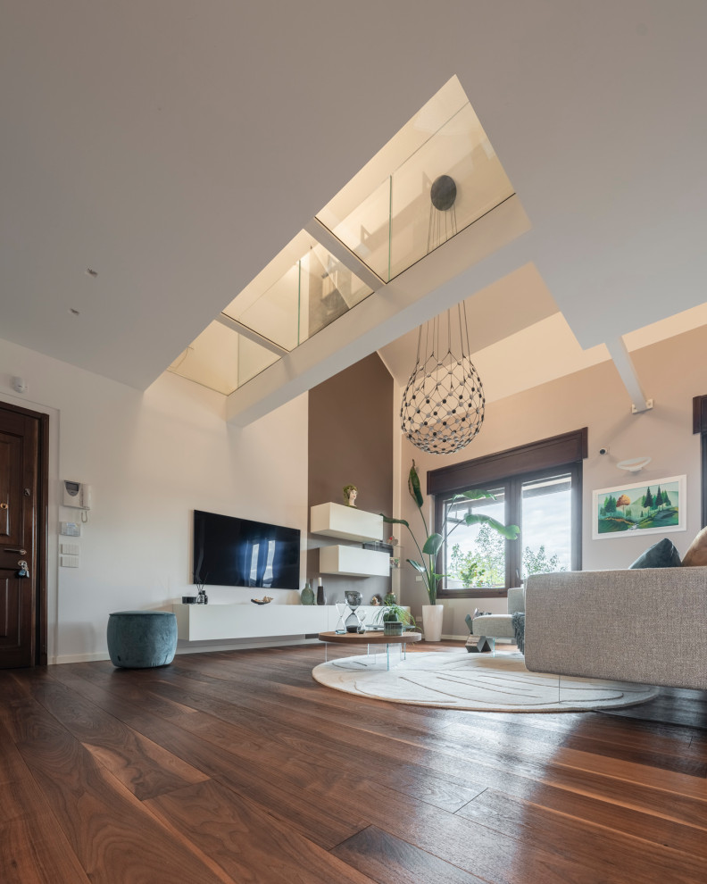 This is an example of a large modern open plan living room in Milan with white walls, dark hardwood flooring, a built-in media unit, brown floors, a drop ceiling and wallpapered walls.