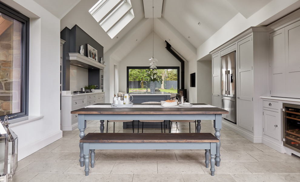 Large contemporary galley open plan kitchen in Manchester with a built-in sink, shaker cabinets, grey cabinets, quartz worktops, white splashback, engineered quartz splashback, stainless steel appliances, an island and white worktops.