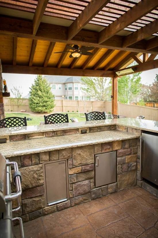 Example of a backyard deck design in Denver with a pergola