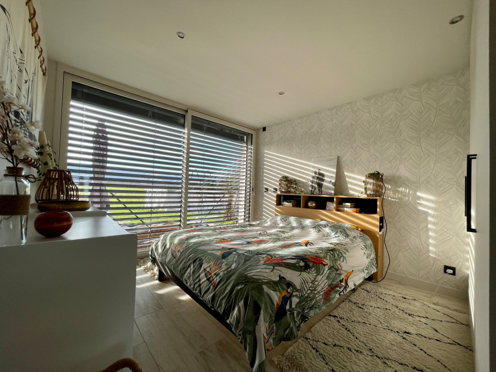 Exemple d'une chambre parentale tendance de taille moyenne avec un mur blanc, un sol en carrelage de céramique, un sol beige, du papier peint et dressing.