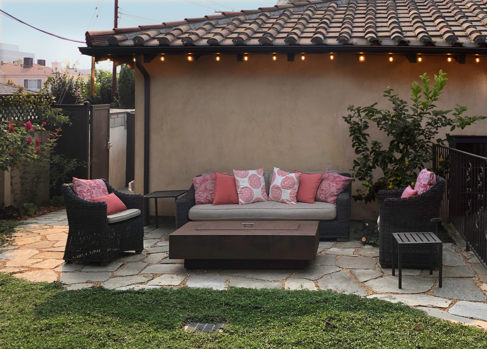 Design ideas for a small eclectic backyard patio in Los Angeles with a fire feature and natural stone pavers.