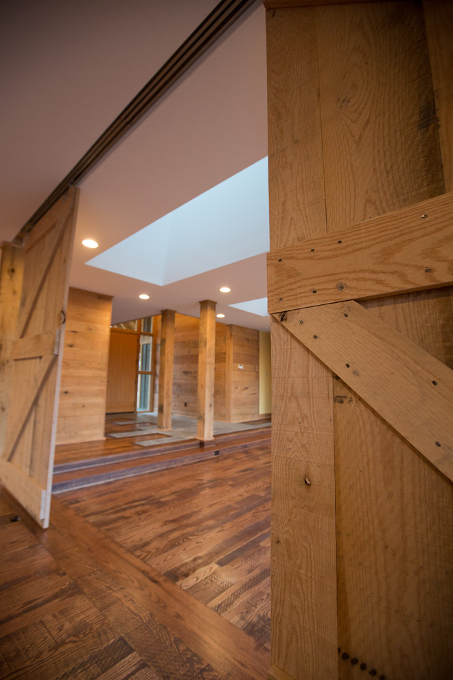 Inspiration for a large rustic formal and open concept dark wood floor home design remodel with orange walls, a standard fireplace, a stone fireplace and no tv