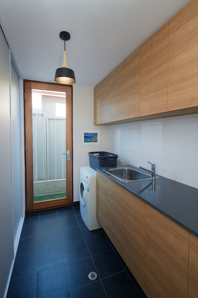 Mid-sized contemporary single-wall utility room in Perth with a drop-in sink, medium wood cabinets, quartz benchtops, white walls and ceramic floors.