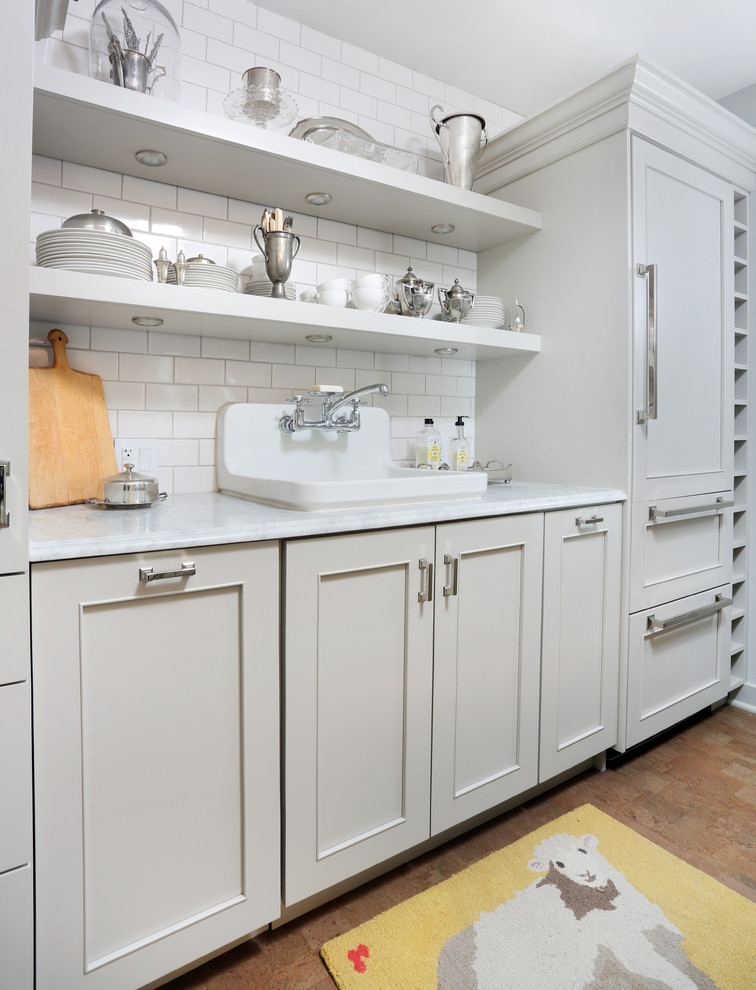 This is an example of a small transitional galley separate kitchen in Chicago with a drop-in sink, grey cabinets, marble benchtops, white splashback, subway tile splashback, panelled appliances, cork floors, no island and shaker cabinets.