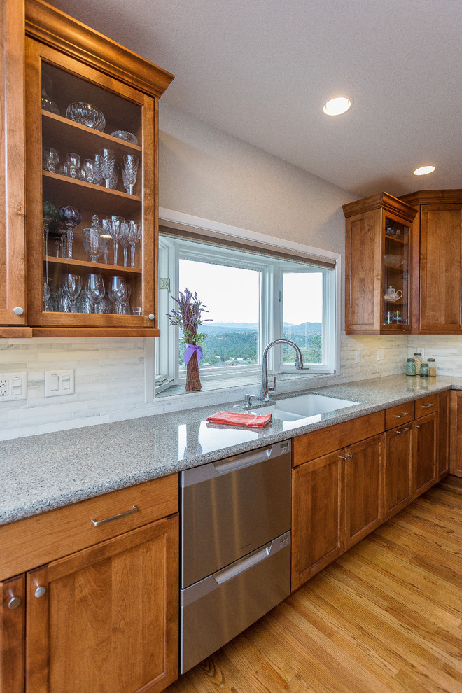 Example of a large transitional u-shaped medium tone wood floor and brown floor enclosed kitchen design in Phoenix with an undermount sink, shaker cabinets, dark wood cabinets, quartz countertops, gray backsplash, stone tile backsplash, stainless steel appliances and an island