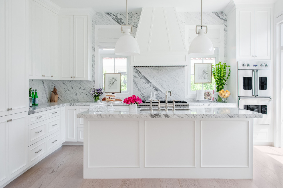 Inspiration för ett mellanstort vintage vit vitt u-kök, med en undermonterad diskho, vita skåp, marmorbänkskiva, stänkskydd i marmor, integrerade vitvaror, ljust trägolv och en köksö