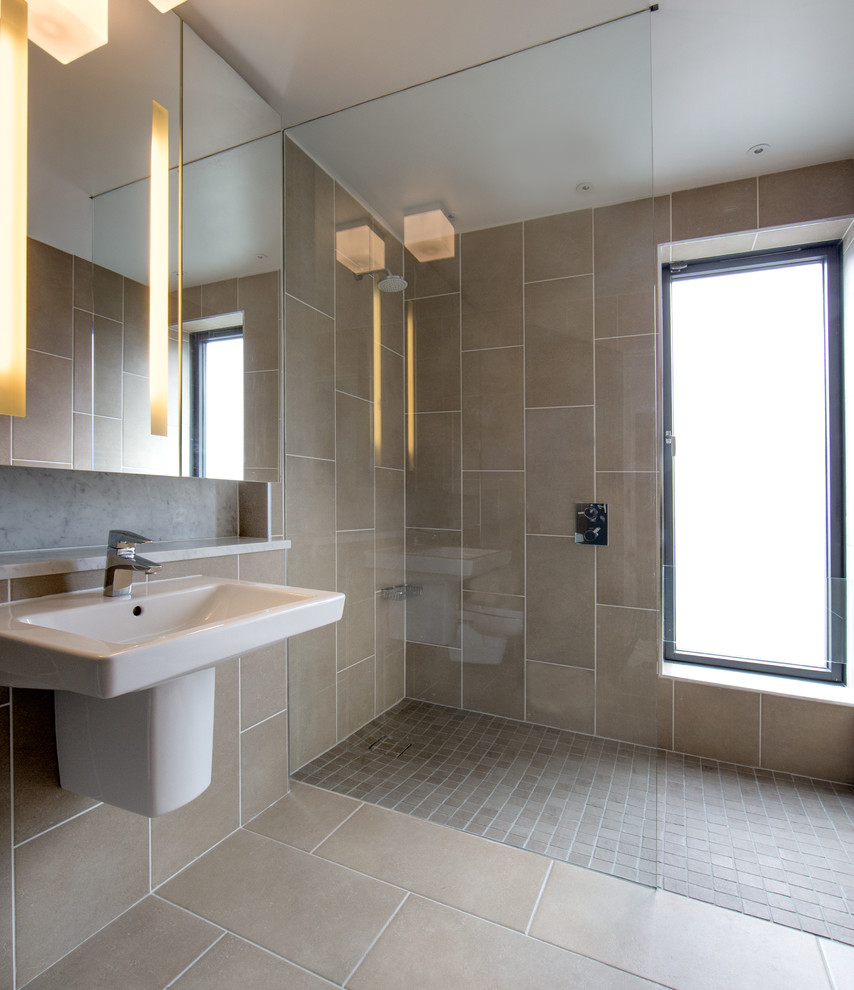 Inspiration for a mid-sized contemporary kids wet room bathroom in Dublin with glass-front cabinets, a wall-mount toilet, brown tile, ceramic tile, brown walls, ceramic floors, a wall-mount sink, engineered quartz benchtops and brown floor.