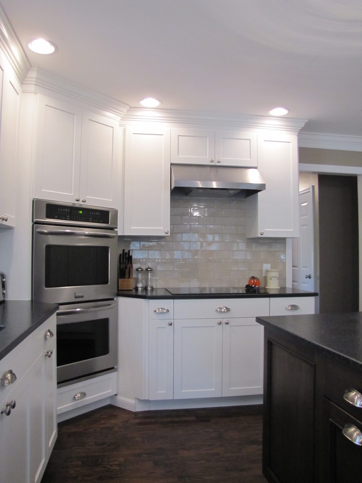 Eat-in kitchen - mid-sized transitional u-shaped dark wood floor eat-in kitchen idea in New York with an undermount sink, shaker cabinets, granite countertops, beige backsplash, porcelain backsplash, stainless steel appliances, beige cabinets and an island
