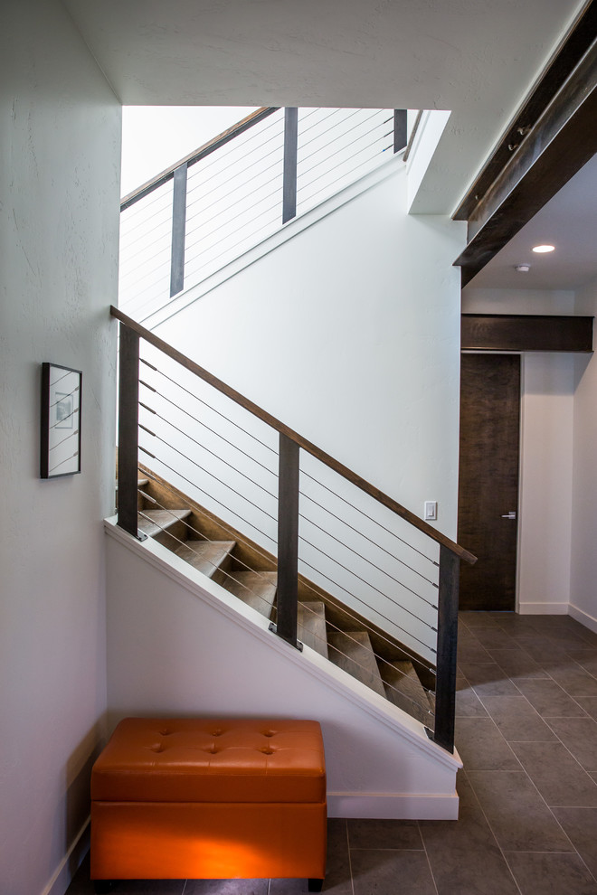 Inspiration for a large transitional wooden u-shaped cable railing staircase remodel with wooden risers