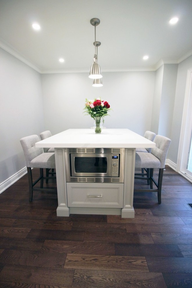Eat-in kitchen - mid-sized transitional u-shaped medium tone wood floor and brown floor eat-in kitchen idea in Toronto with an undermount sink, shaker cabinets, white cabinets, quartzite countertops, white backsplash, ceramic backsplash, stainless steel appliances, an island and white countertops
