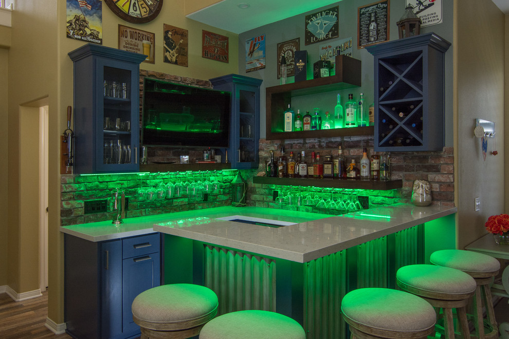 This is an example of a large eclectic u-shaped seated home bar in Los Angeles with no sink, open cabinets, blue cabinets, quartzite benchtops, red splashback, brick splashback, medium hardwood floors and brown floor.