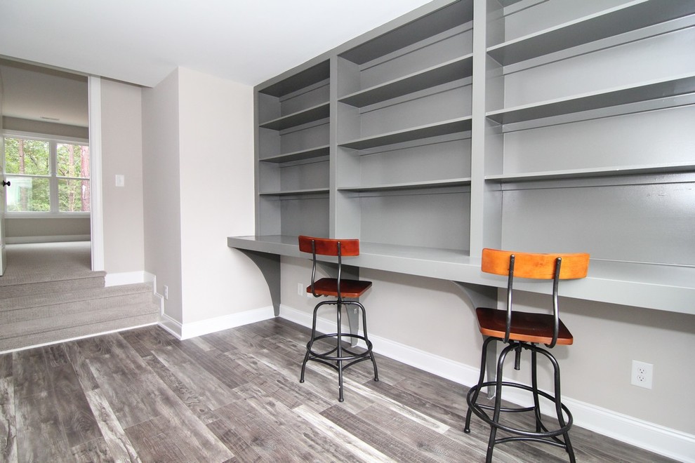Photo of a mid-sized arts and crafts craft room in Raleigh with grey walls, ceramic floors and a built-in desk.