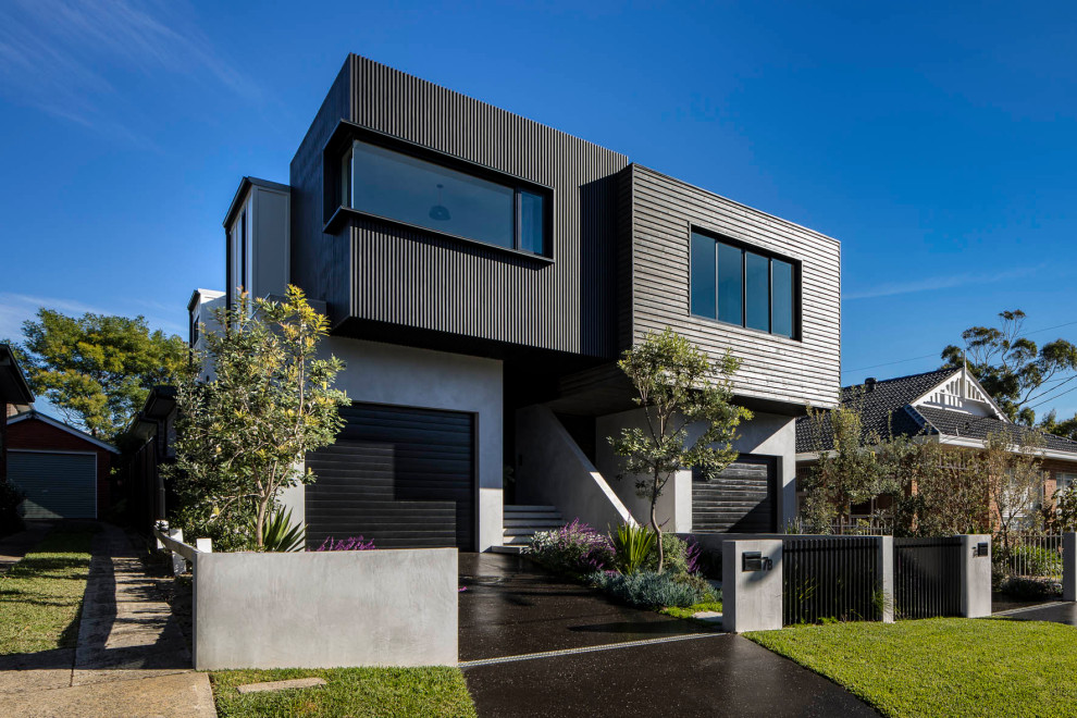 This is an example of an industrial two-storey concrete black duplex exterior in Sydney with a black roof.