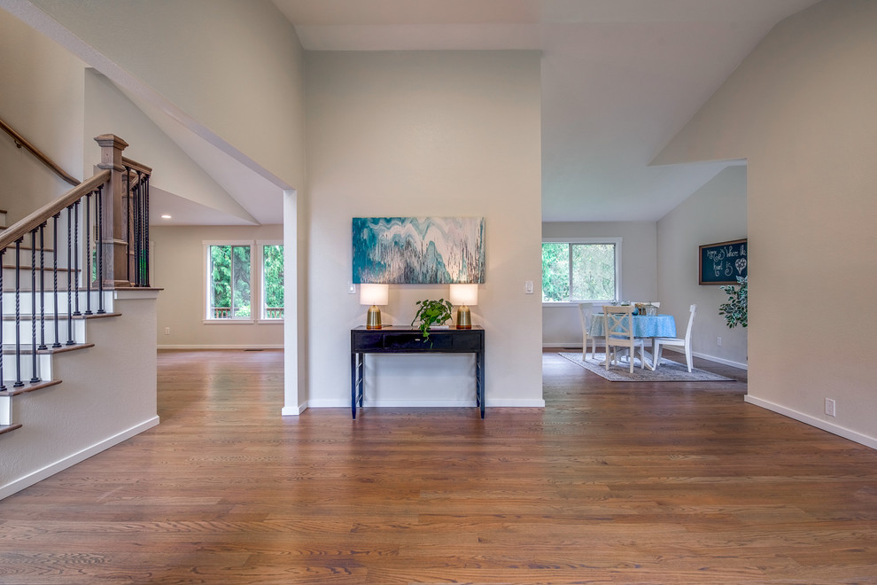 Photo of a mid-sized transitional foyer in Orange County with white walls, a single front door, a blue front door, medium hardwood floors and brown floor.