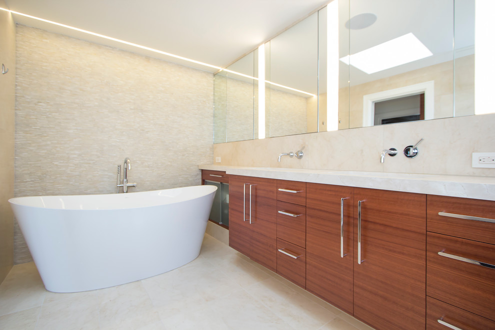 Photo of a mid-sized contemporary master bathroom in San Francisco with flat-panel cabinets, medium wood cabinets, a curbless shower, beige tile, limestone, beige walls, limestone floors, an undermount sink, limestone benchtops, beige floor and a hinged shower door.