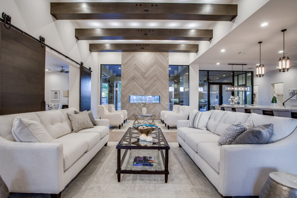 Photo of a mid-sized transitional formal open concept living room in Dallas with beige walls, medium hardwood floors, a two-sided fireplace, a tile fireplace surround, no tv and brown floor.