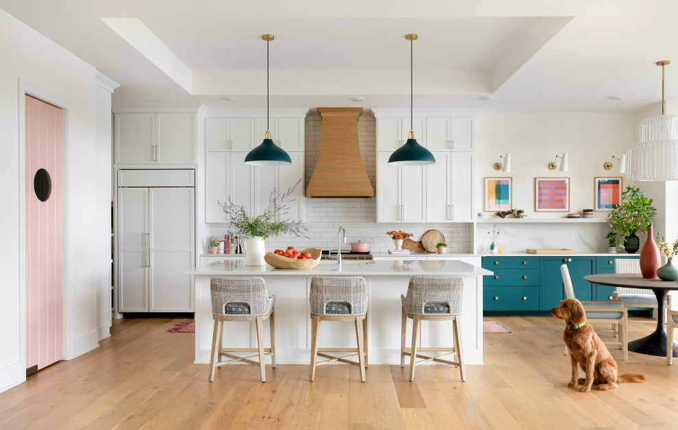 Inspiration for a large beach style galley kitchen in Minneapolis with an undermount sink, flat-panel cabinets, white cabinets, quartz benchtops, white splashback, ceramic splashback, panelled appliances, light hardwood floors, with island, brown floor, white benchtop and coffered.