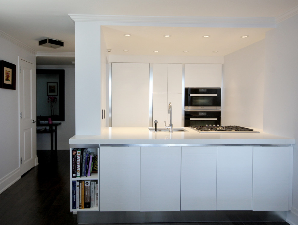 This is an example of a small modern kitchen in New York with flat-panel cabinets and white cabinets.