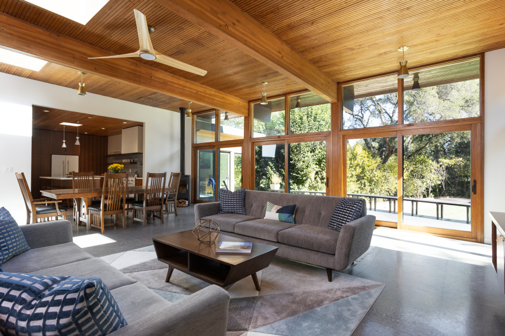 Immagine di un soggiorno moderno aperto con pavimento in cemento, travi a vista, pavimento grigio e con abbinamento di mobili antichi e moderni