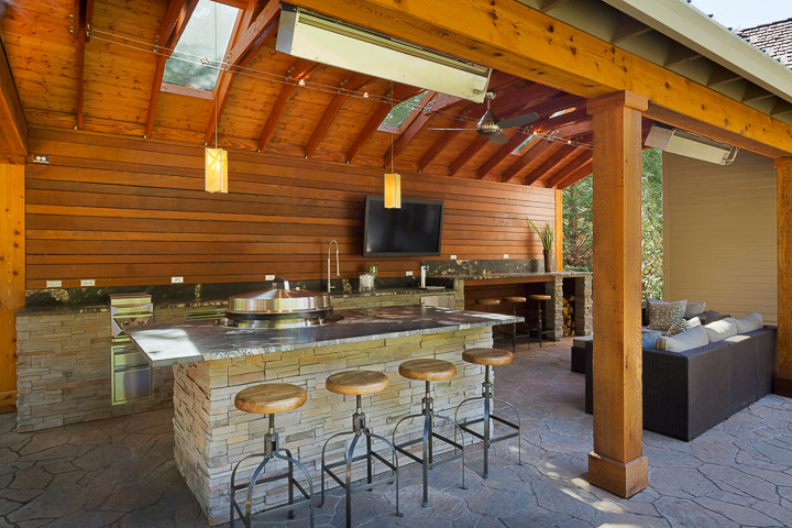 Mid-sized transitional backyard patio in Portland with an outdoor kitchen, concrete pavers and a roof extension.